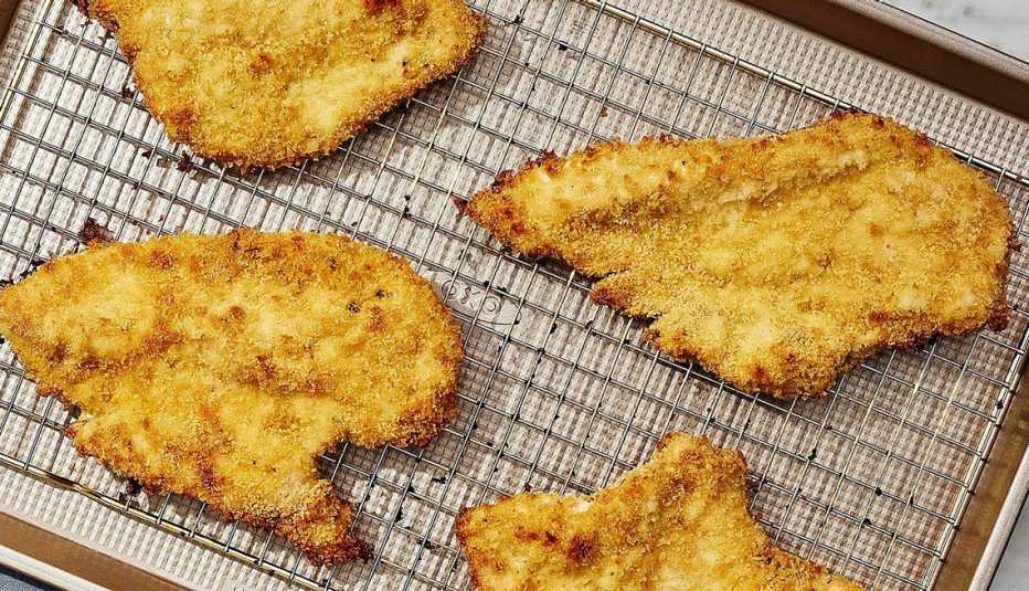 Crispy baked chicken cutlets A close-up view of crispy baked chicken cutlets on a pan