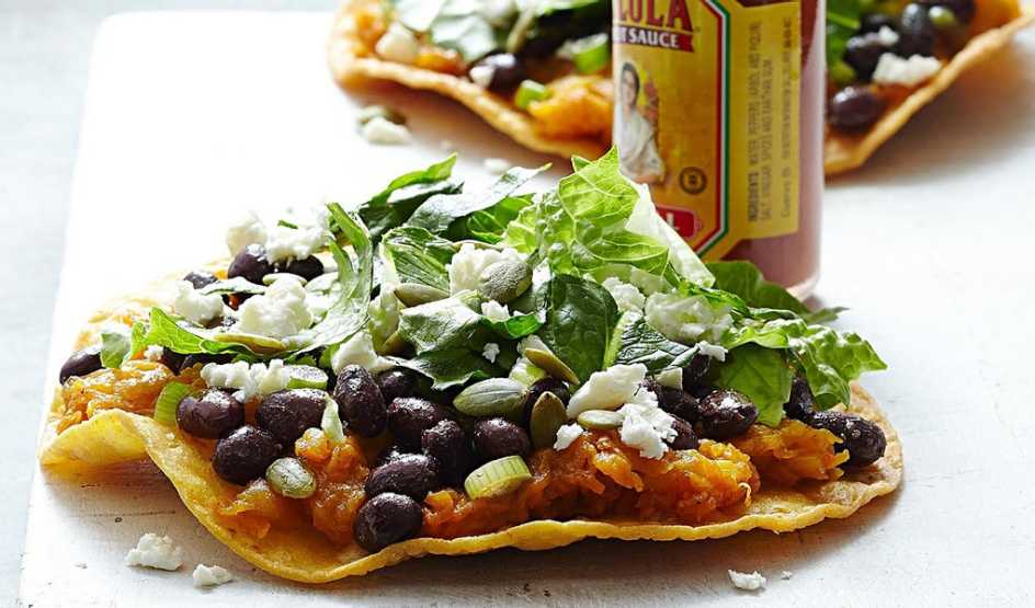 A close-up view of butternut squash and black bean tostadas