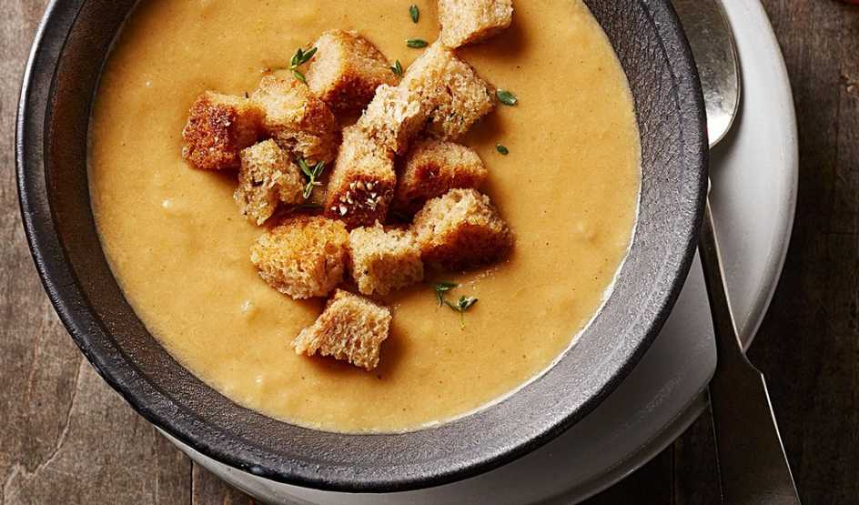 A close-up view of cauliflower soup with smoked gouda in a bowl