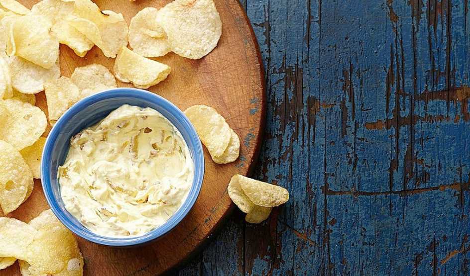 A close-up view of curried onion dip with chips