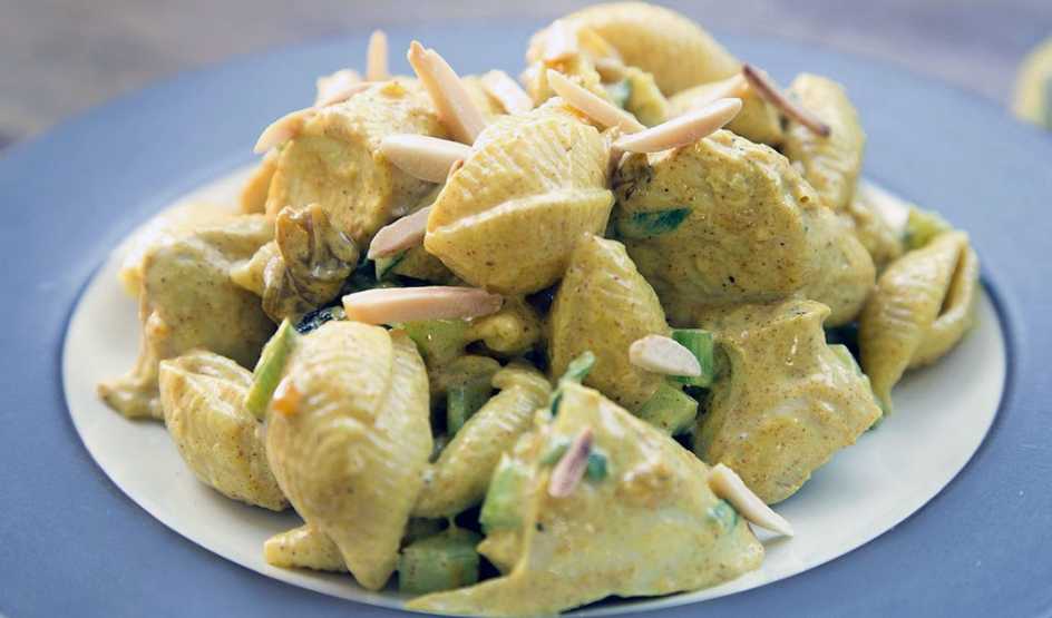 A close-up view of curried chicken and pasta salad on a plate