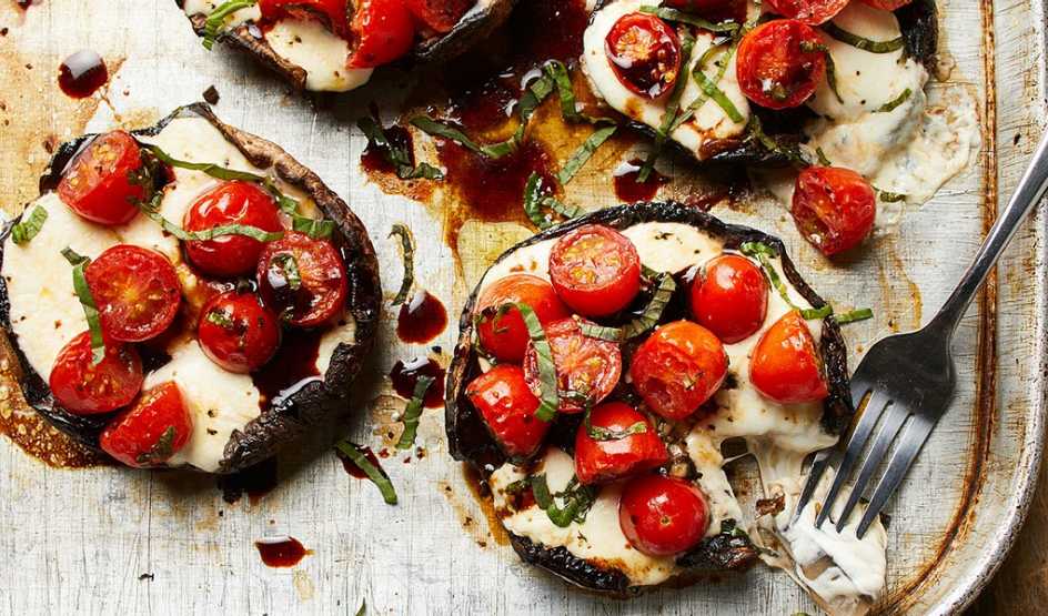 A close-up view of caprese stuffed portobello mushrooms on a board