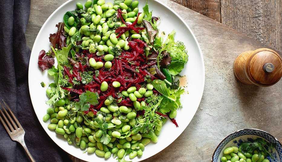 Green salad with edamame and beets A close-up view of a green salad with edamame and beets on a plate