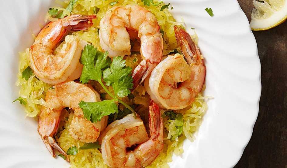 A close-up view of garlic shrimp with cilantro spaghetti squash on a plate