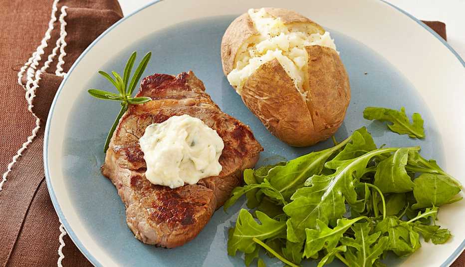 A close-up view of seared steak with roasted garlic aïoli on a plate