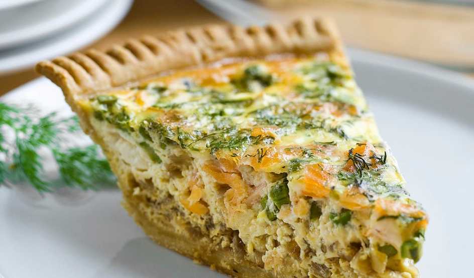 A close-up view of asparagus and smoked salmon quiche on a plate