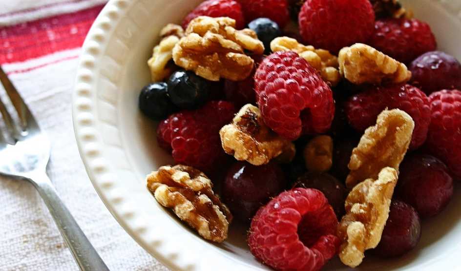 A close-up view of berries and walnuts in a bowl