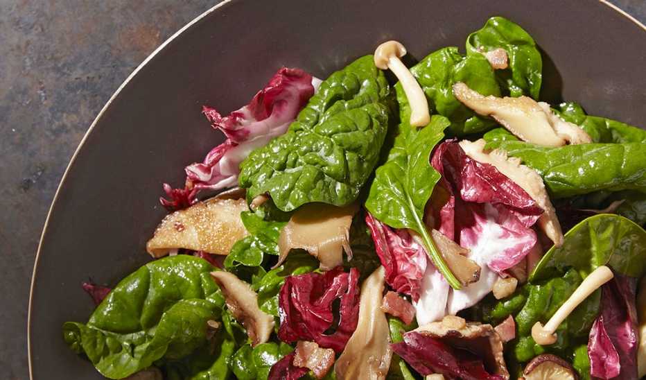 Spinach and warm mushroom salad A close-up view of spinach and warm mushroom salad in a pan