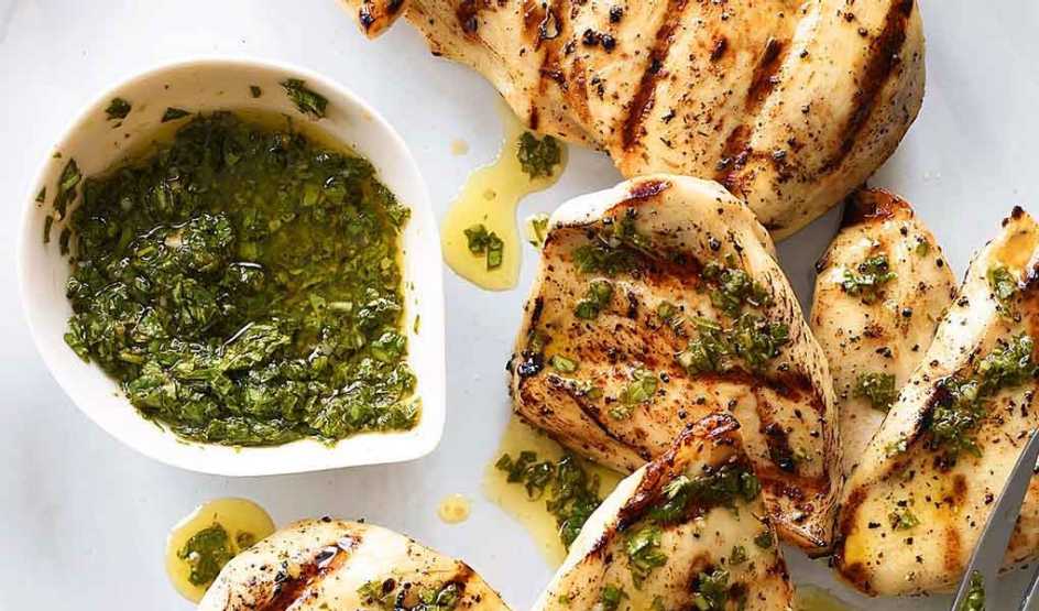 A close-up view of chicken breast with basil-mint sauce