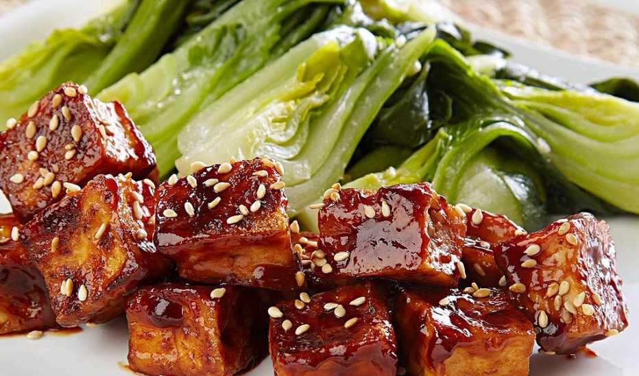 A close-up view of crispy glazed tofu with bok choy
