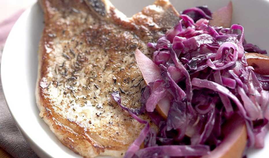 A close-up view of pork chops with red cabbage and pears on a plate A close-up view of pork chops with red cabbage and pears on a plate