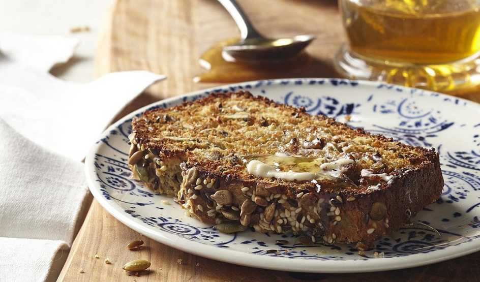 A close-up view of a seeded whole-grain quick bread on a plate