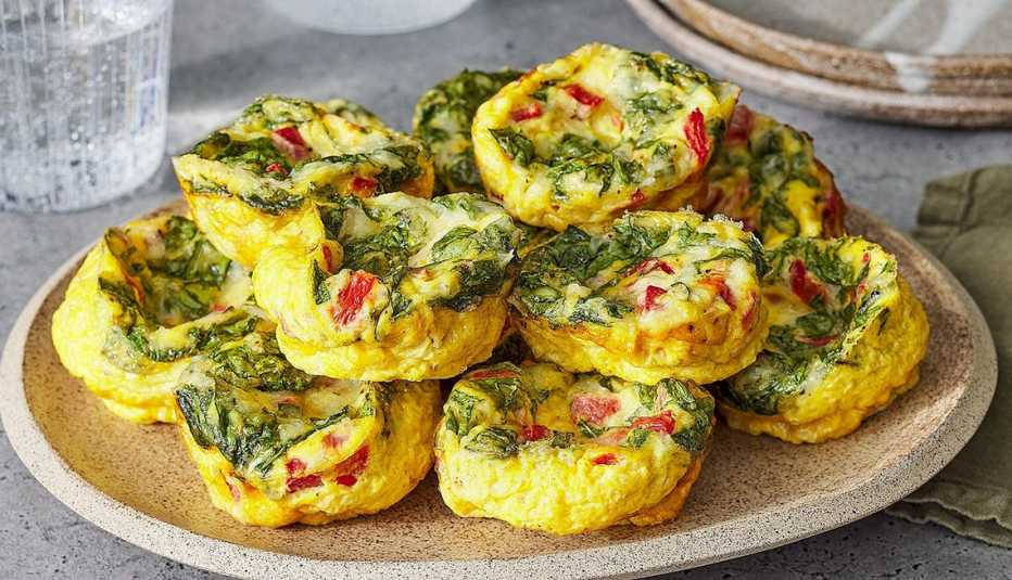 Roasted red pepper and spinach egg bites A close-up view of roasted red pepper and spinach egg bites on a plate