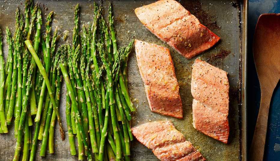 Salmon and asparagus with lemon-garlic butter sauce A close-up view of salmon and asparagus with lemon-garlic butter sauce on a sheet pan