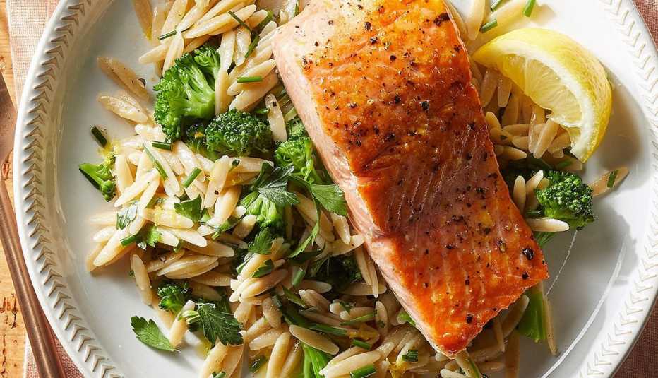 Salmon with lemon-herb orzo and broccoli A close-up view of salmon with lemon-herb orzo and broccoli on a plate