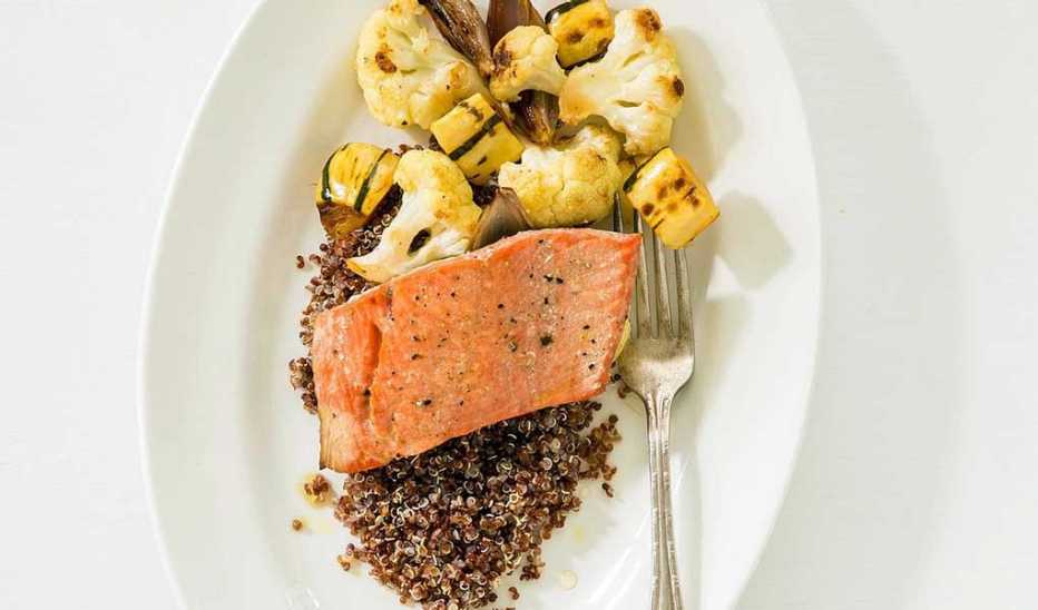 A close-up view of salmon with roasted vegetables and quinoa on a plate A close-up view of salmon with roasted vegetables and quinoa on a plate
