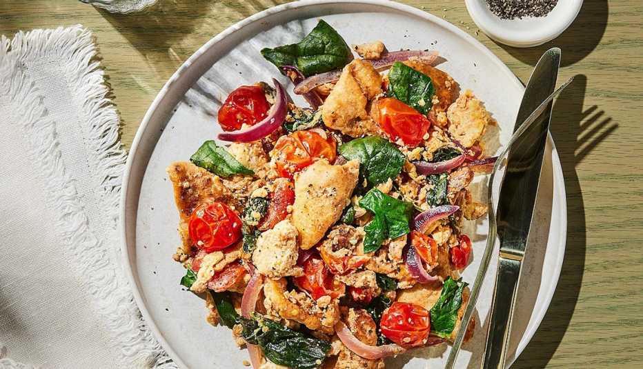 Scrambled eggs with spinach, feta and pita A close-up view of scrambled eggs with spinach, feta and pita on a plate