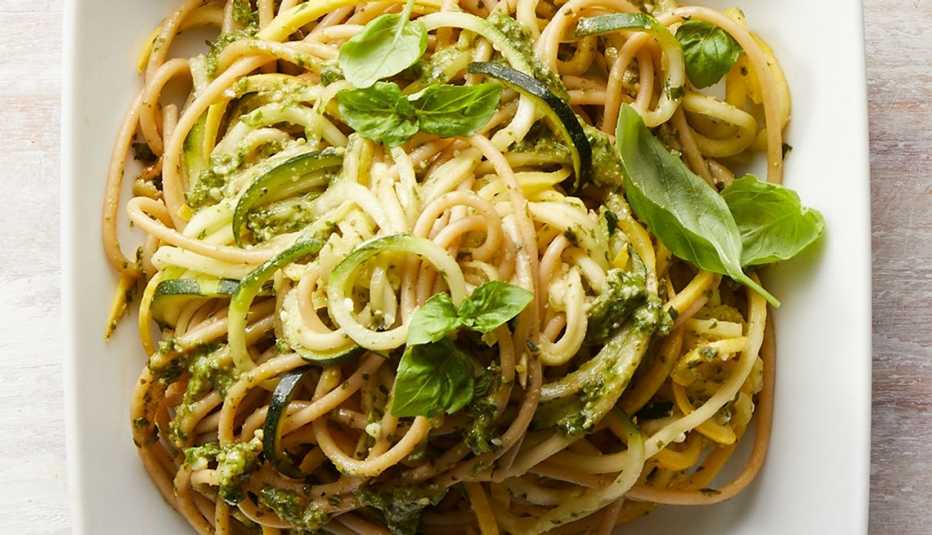Spaghetti and zucchini noodles with basil-walnut pesto A close-up view of spaghetti and zucchini noodles with basil-walnut pesto on a plate