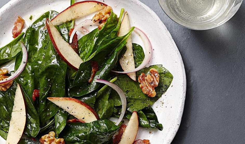 Warm pear and spinach salad with maple-bacon vinaigrette A close-up view of warm pear and spinach salad with maple-bacon vinaigrette on a plate