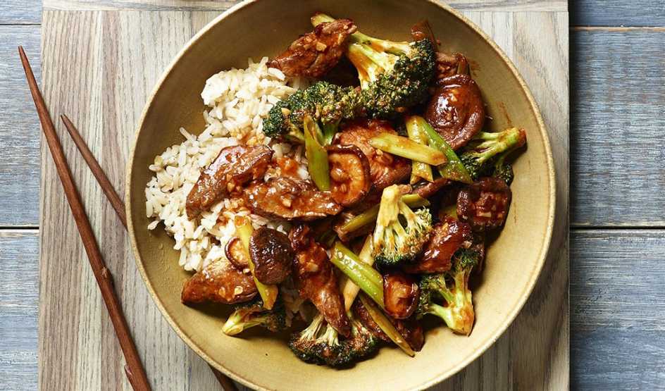 A close-up view of broccoli, mushroom and beef stir-fry in a plate