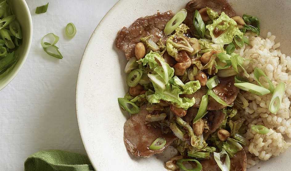 A close-up view of cabbage and pork stir-fry with peanuts