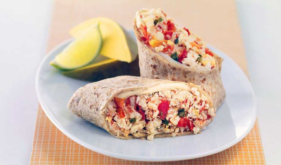 A close-up view of salsa-tofu breakfast burrito on a plate