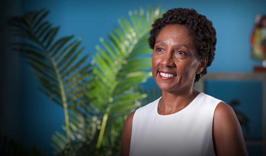 A woman, Olivia Affuso, smiling and sitting on camera