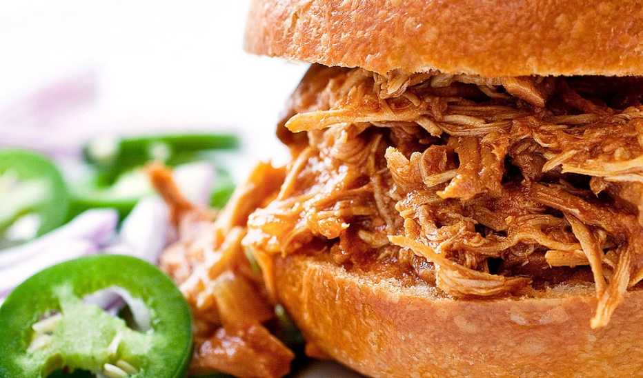 A close-up view of a barbecue pulled chicken sandwich