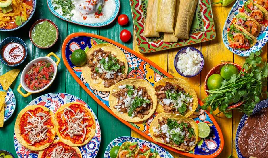 An overhead view of plates of different Mexican foods