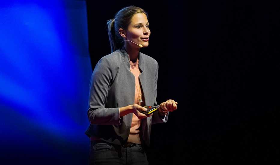 A woman, Giulia Enders, speaking on stage at a TED event