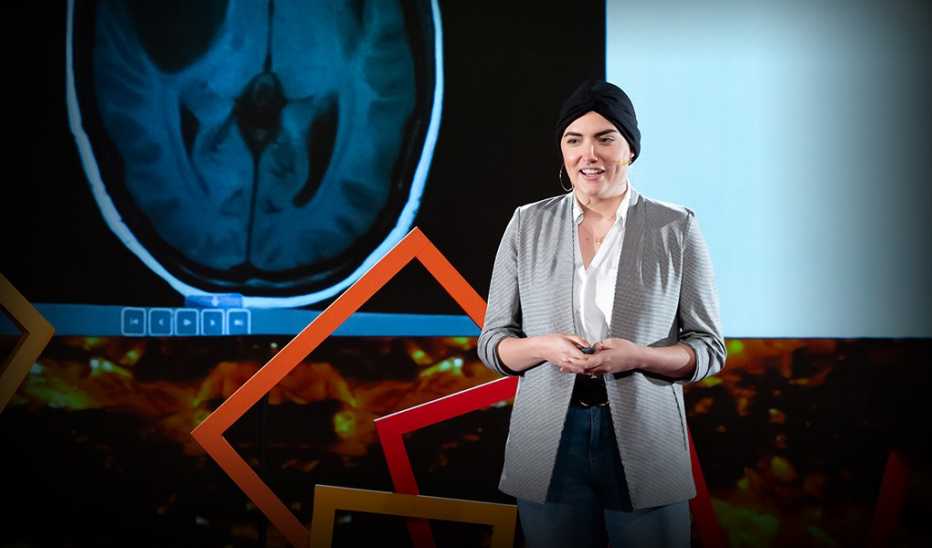 A woman, Christina Costa, speaking on stage at a TED event