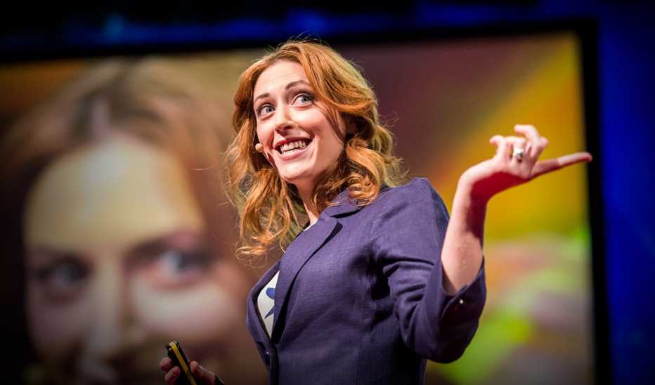 A woman, Kelly McGonigal, speaks on stage in front of a crowd