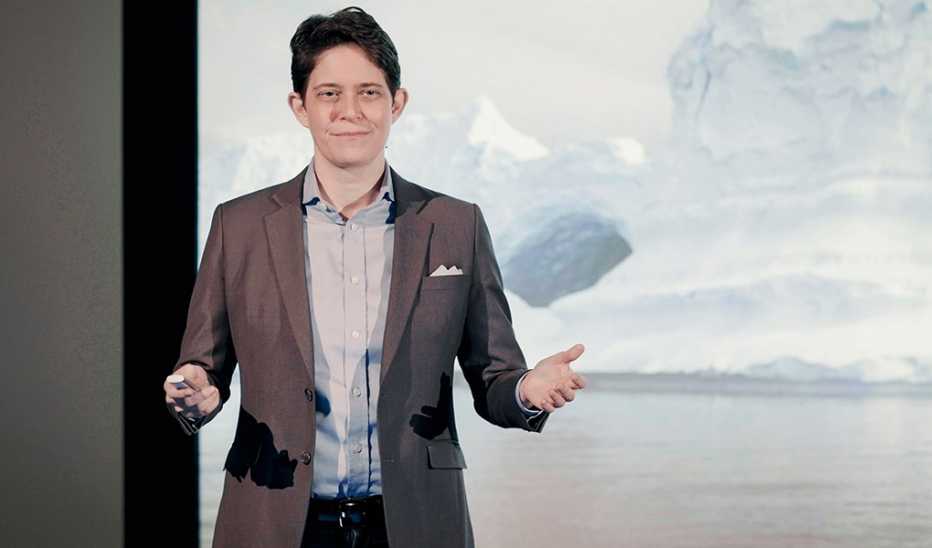 A man, Dorie Clark, speaking on stage at a TED event