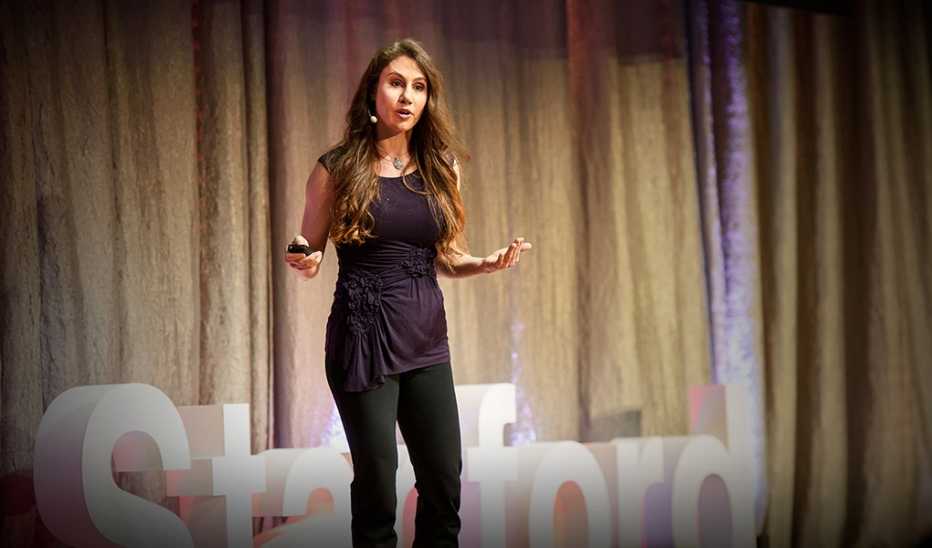 A woman, Marily Oppezzo, speaking on stage at a TED event