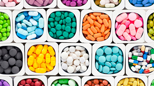 A variety of multicolored brain health supplements in a plastic container.