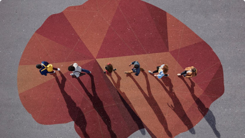 An overhead shot of people walking in a line over a painting of a brain on the ground