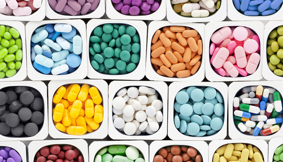 A variety of multicolored brain health supplement pills inside plastic containers
