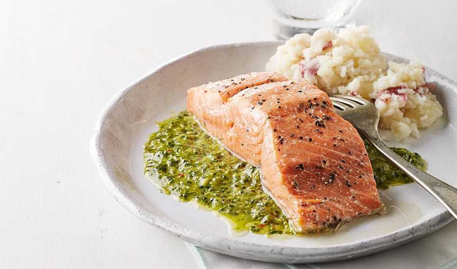 A close-up view of roast salmon with chimichurri sauce on a plate