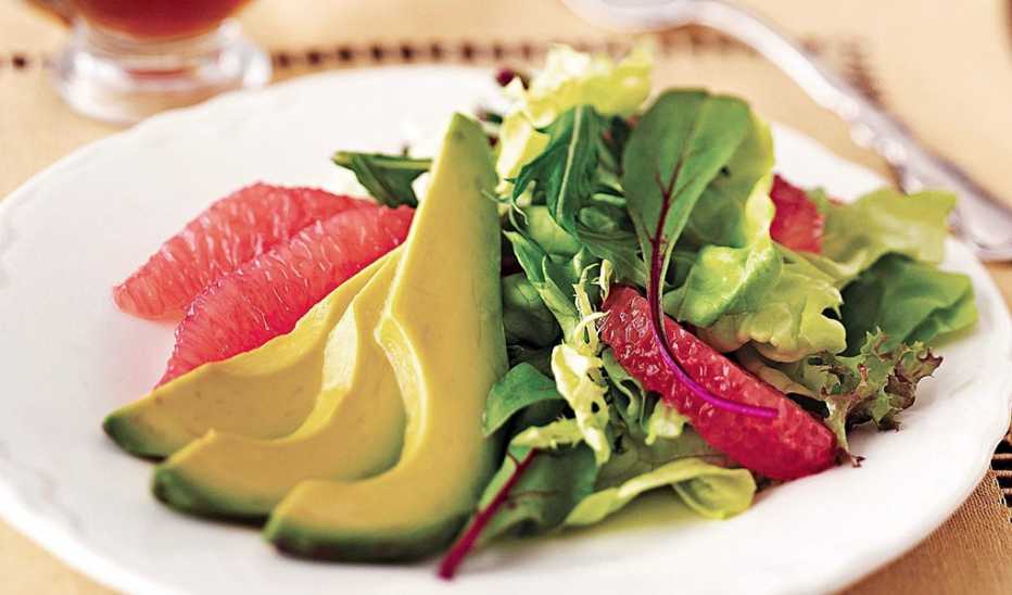 A close-up view of avocado and grapefruit salad on a plate