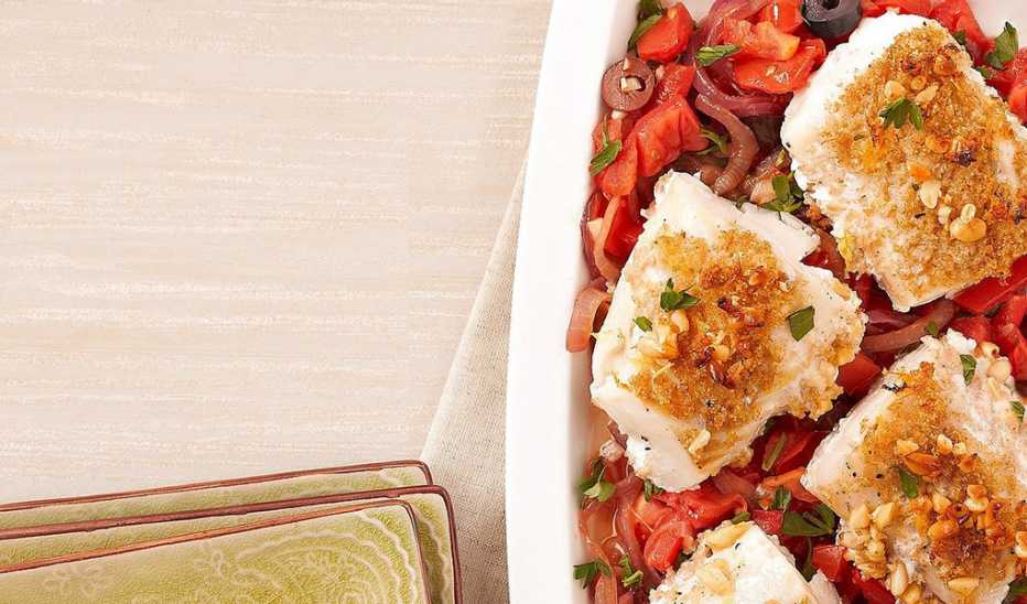 A close-up view of nut-crusted cod with caramelized onions