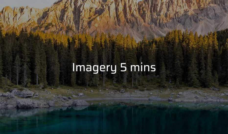 A body of water with trees and mountains in the background 