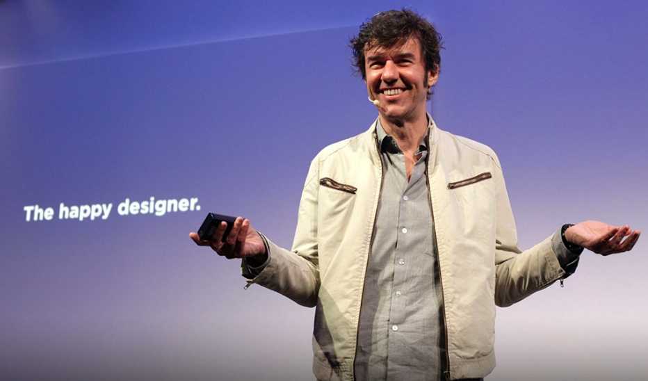 A man, Stefan Sagmeister, speaking on stage at a TED event