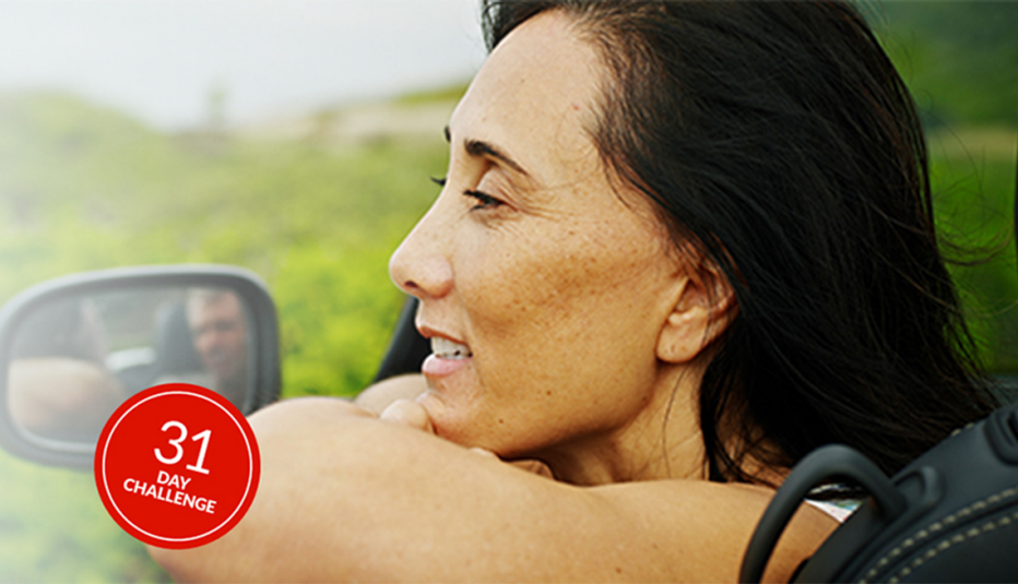 A woman looking out of an open car window and smiling