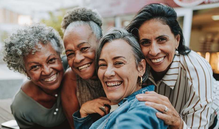 Four women smiling and taking a selfie together