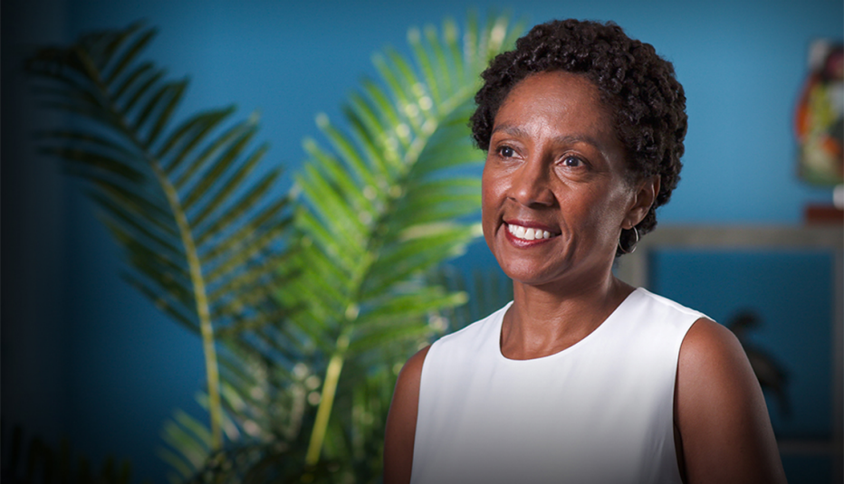 A woman, Olivia Affuso, smiling and sitting on camera
