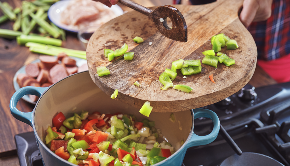 A cast iron pot of cajun-style chicken, shrimp and sausage jambalaya being prepared