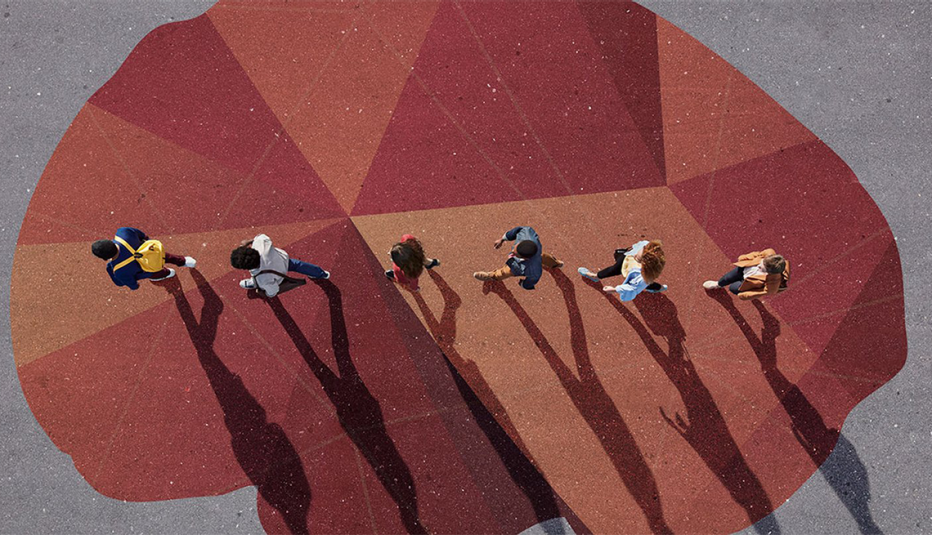 An overhead shot of a line of people walking over a painting of a brain