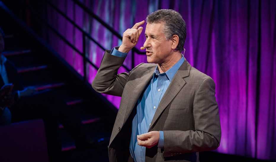 A man, Daniel Levitin, speaking on stage at a TED event