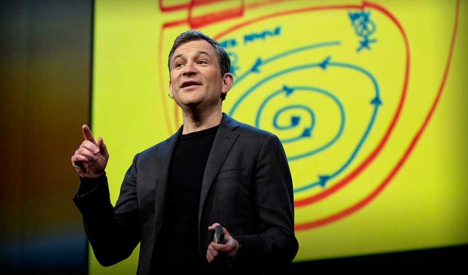 A man, Dan Harris, speaking on stage at a TED event