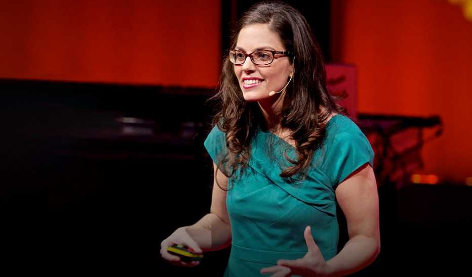 A woman, Molly Crockett, speaking on stage at the TEDSalon London Fall 2012